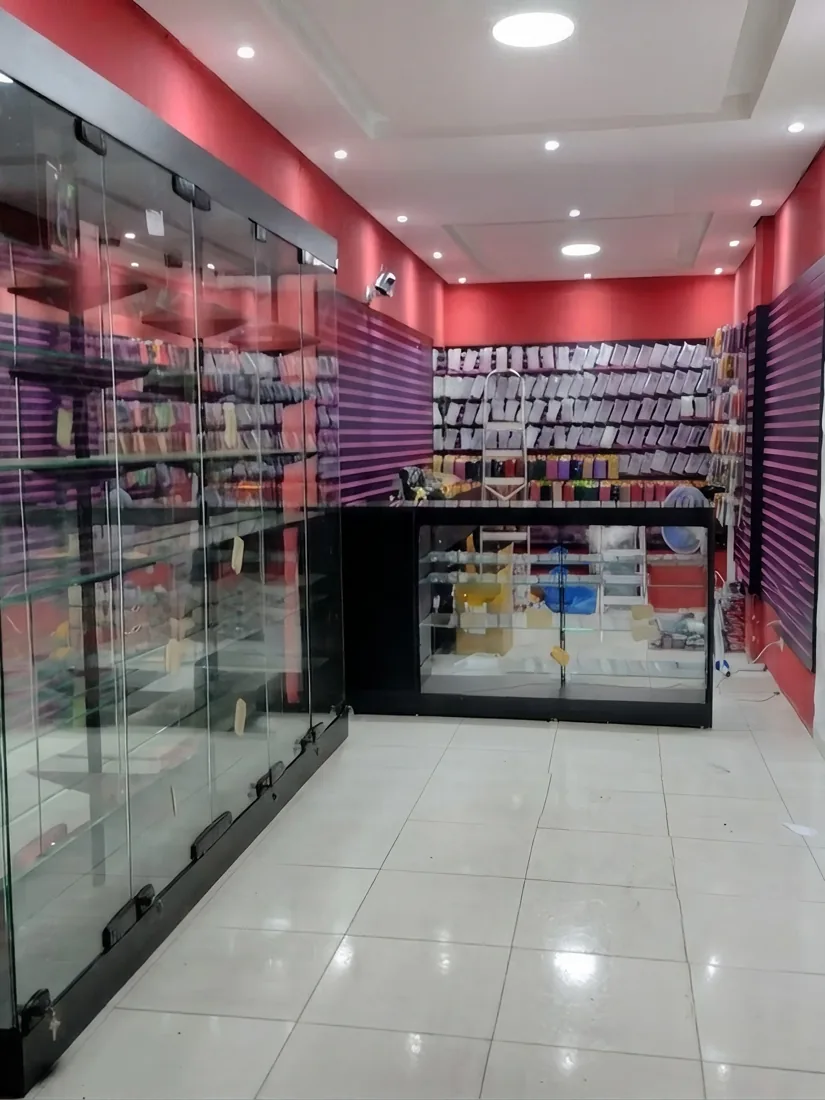 Loja de acessórios para celular montada pela ModFix com vitrine de vidro, painéis canaletados roxos e balcão expositor